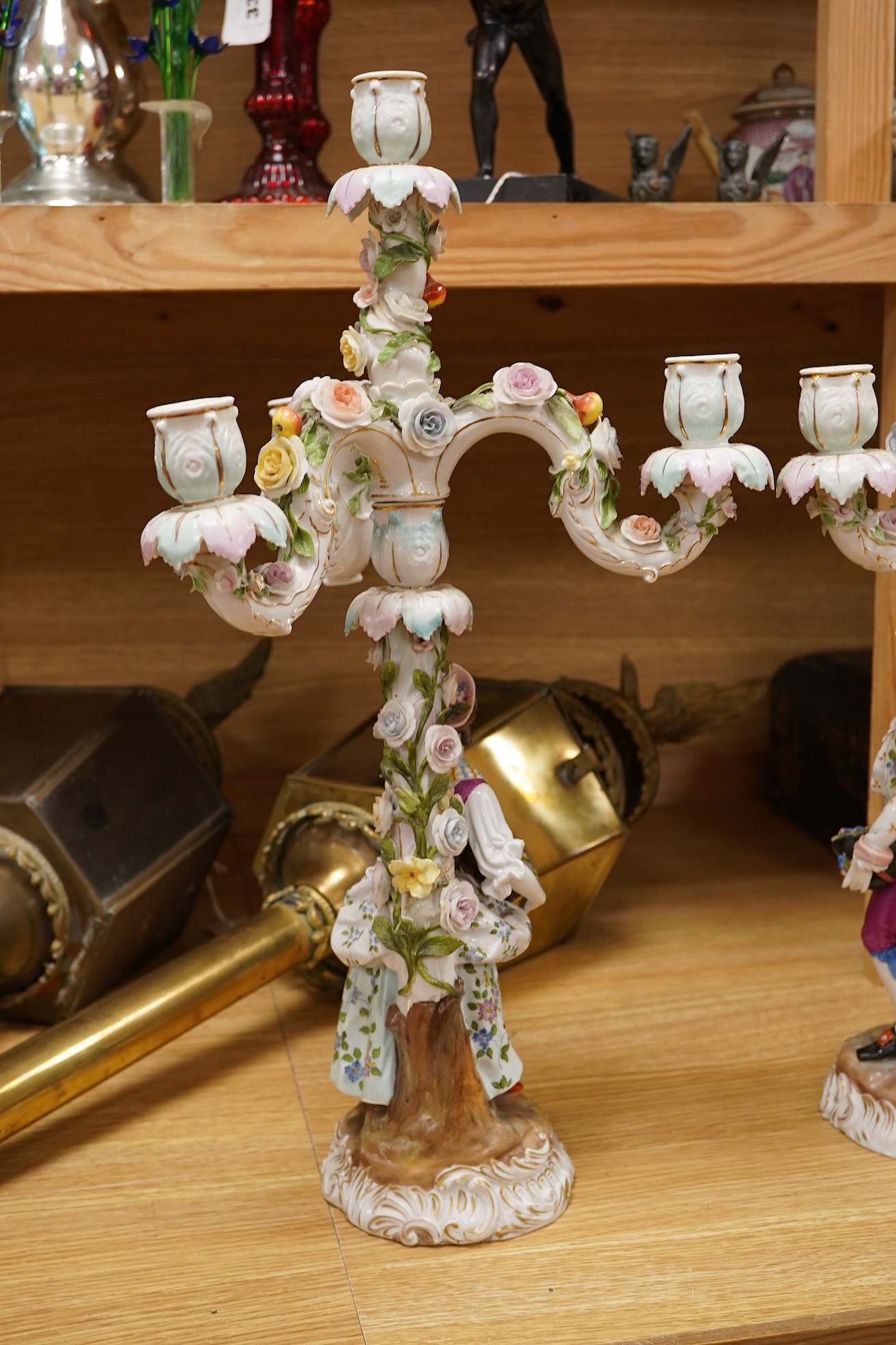A pair of Volkstedt porcelain figural three branch candelabra with floral encrusted decoration, 51cm high